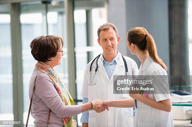 doctor shaking hands with his patient at hospital reception - reception of france stock pictures, royalty-free photos & images