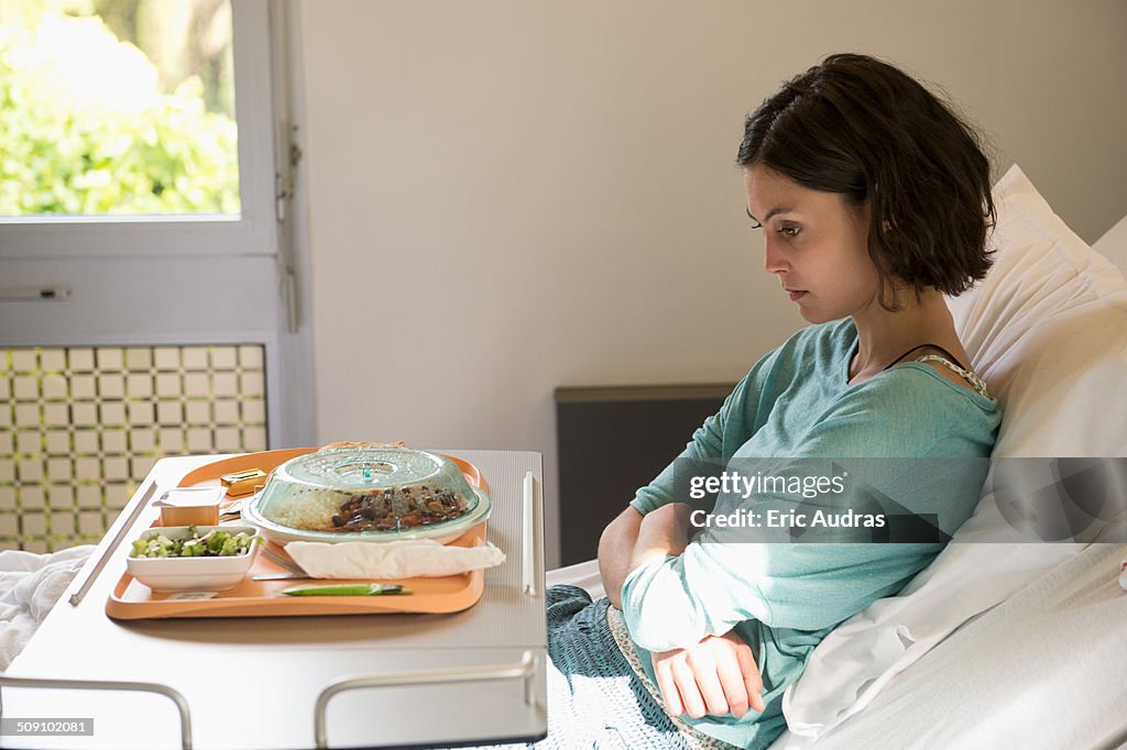 Anorexia nervosa patient with a food tray in hospital ward
