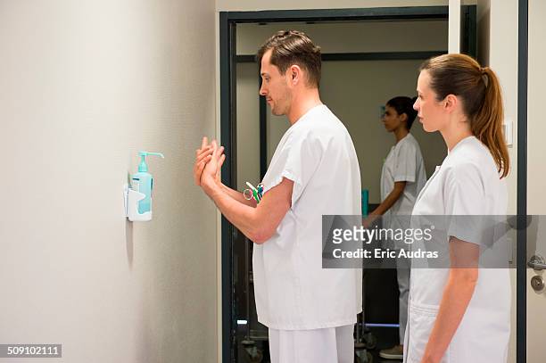 male doctor using hygiene hand wash in hospital room - antiséptico fotografías e imágenes de stock
