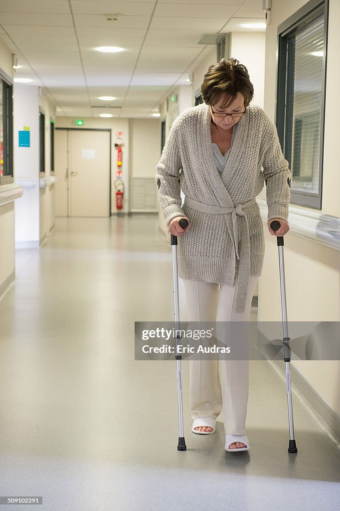 Female patient walking with the help of crutches