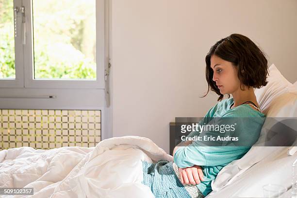 female depressed patient sitting on the bed in a hospital ward - psychiatric ward stock pictures, royalty-free photos & images