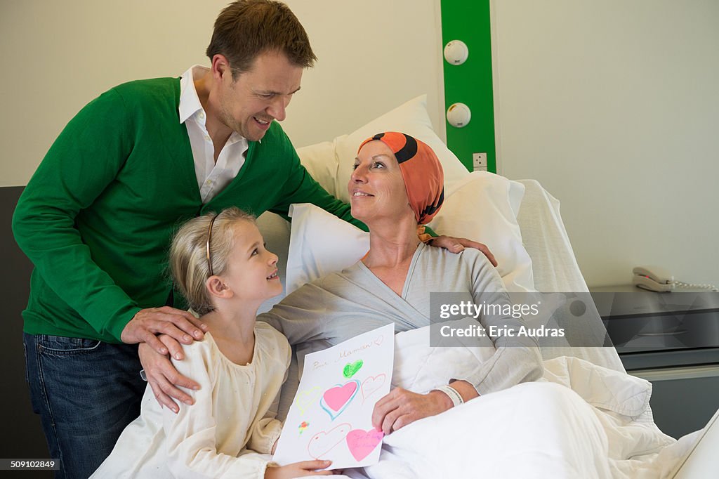 Girl with her father visiting to her mother in hospital
