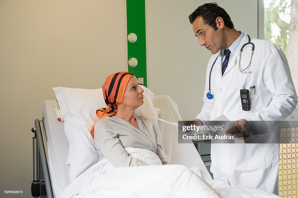 Male doctor discussing medical report with a cancer patient