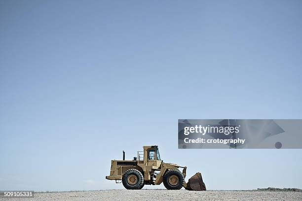 usa, wyoming, bulldozer against blue sky - construction vehicle stock pictures, royalty-free photos & images