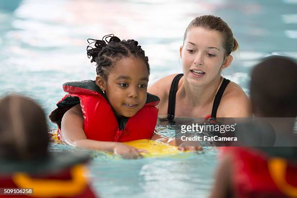 schwimmen trainer arbeiten mit einer kleines mädchen - kinder am wasser stock-fotos und bilder