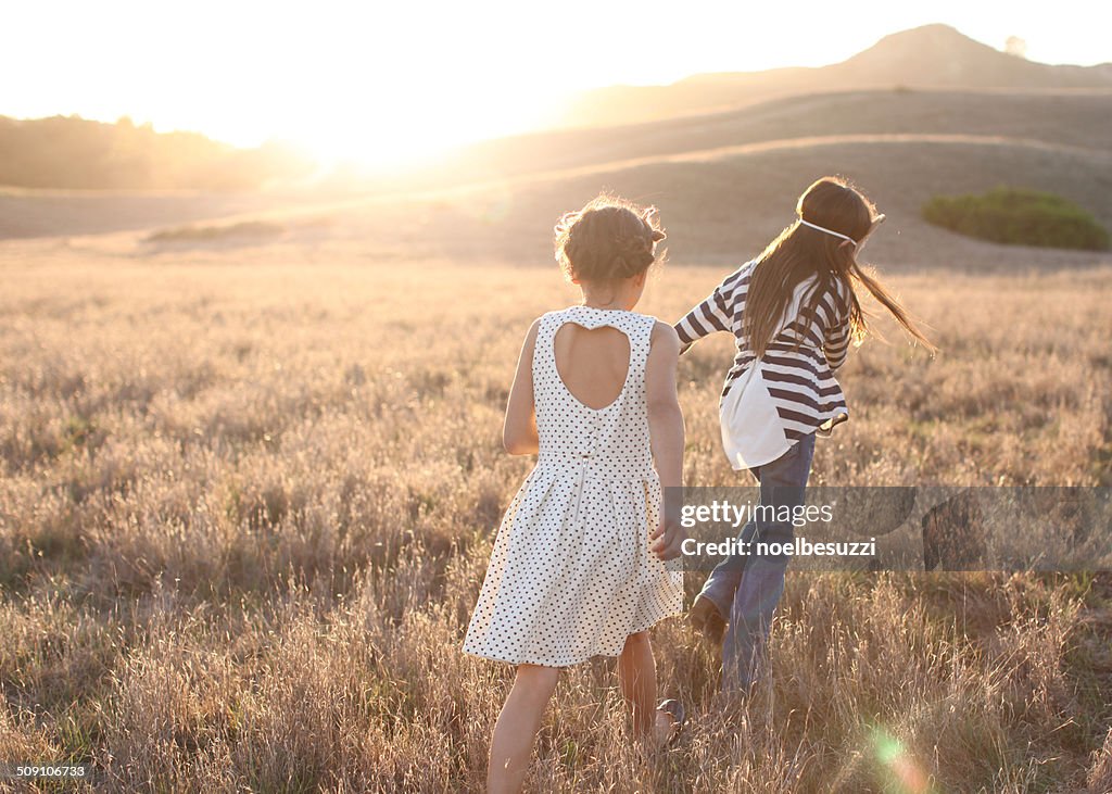 Rear view of two girls walking outdoors