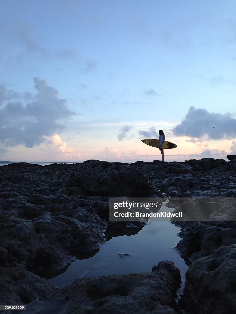 USA, Florida, Duval County, Jacksonville Beach, Side view of woman holding surfboard on beach