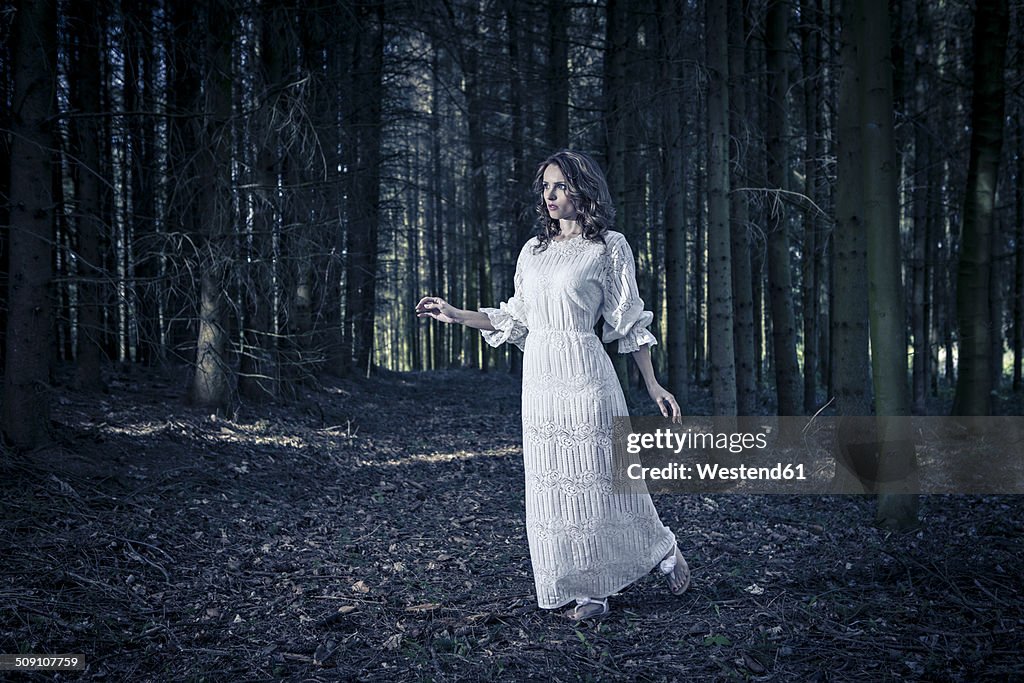 Woman wearing white dress in a forest