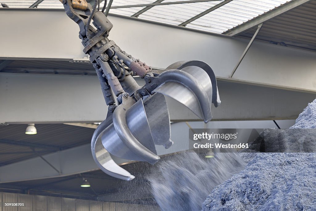 Clamshell grabbing aluminium chips in a scrap metal recycling plant