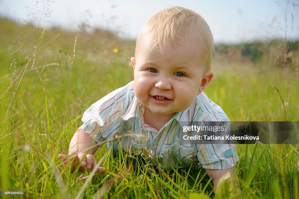 Baby boy crawling on grass