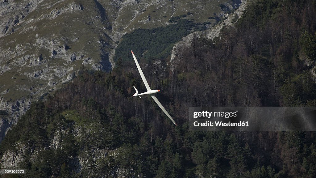 Austria, Salzburg, glider in front of mountain face in the Alps