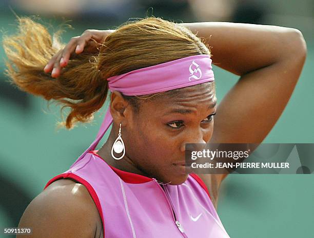 Serena Williams, wearing a headband with her initial "S," fixes her hair during her match against Japanese Shinobu Asagoe in the fourth round of the...