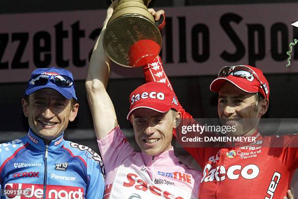 Pink jersey Italian Damiano Cunego flanked by Ukrainian Serhiy Honchar and teammate Gilberto Simoni celebrate on the podium after the last stage of...