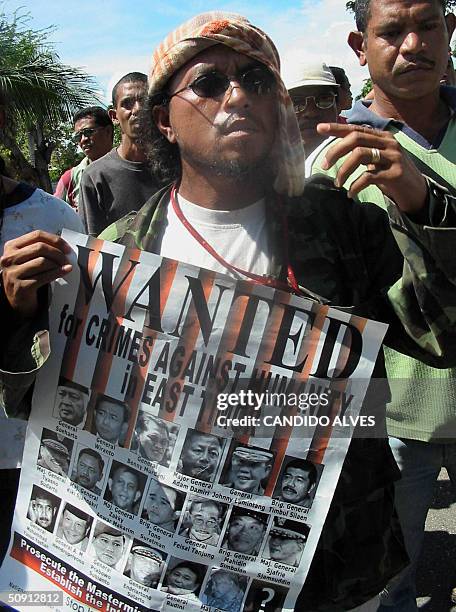 People in East Timor hold a wanted poster showing portraits of former Indonesian leader Suharto and former Indonesian armed forces chief Wiranto ,...