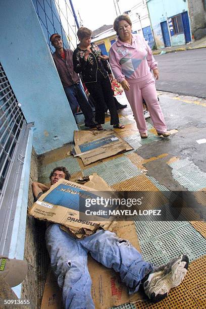 Un joven descansa cobijado con cartones el 20 de mayo de 2004 en una acera de la centrica Avenida 10, en San Jose. La cantidad de indigentes en Costa...