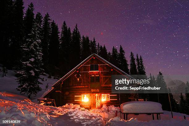 lightened mountain hut in the austrian alps with milky way - hut stock pictures, royalty-free photos & images