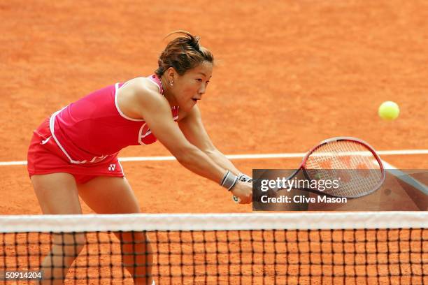 Rika Fujiwara of Japan returns in her fourth round doubles match with Shinobu Asagoe of Japan during Day Eight of the 2004 French Open Tennis...