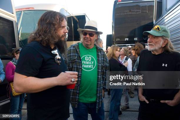 American musicians Jamey Johnson and Willie Nelson , pose with Canadian Neil Young during the Farm Aid benefit concert outside the Verizon Wireless...