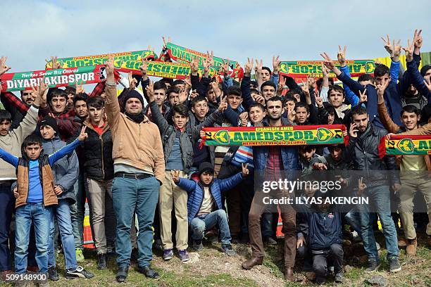 Amedspor's supporters gesture and wave scarves to cheer their team prior to the Turkish Cup football match between Amed Spor and Fenerbahce Zirrat on...