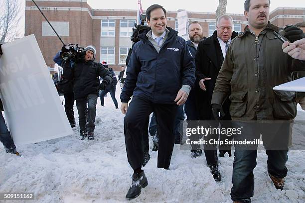 Republican presidential candidate Sen. Marco Rubio walks through the snow after stopping to thank supporters outside the polling place at Webster...