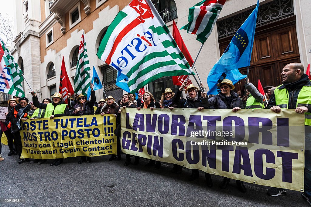 Workers shout slogans, wave flags and hold banners as they...