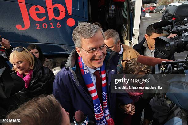 Republican presidential candidate Jeb Bush and his wife Columba Bush wade into a crowd of television cameras after stepping off his campaign bus...