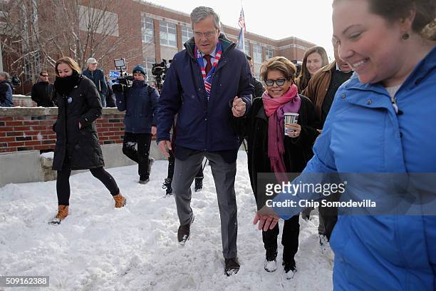 Republican presidential candidate Jeb Bush and his wife Columba Bush carefully tread through the snow while stopping to thank supporters outside the...