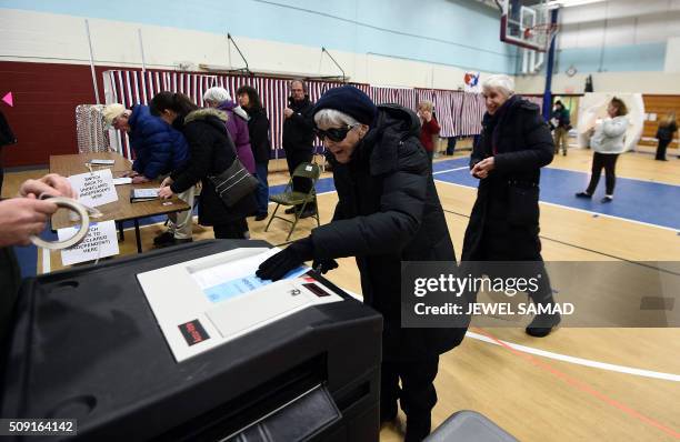 An elderly woman casts her ballot for the first US presidential primary at a school gym in Concord, New Hampshire, on February 9, 2016. New Hampshire...