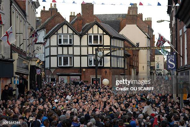 Competitors from the opposing teams, the Up'ards and the Down'ards, reach for the ball during the annual Royal Shrovetide Football Match in...