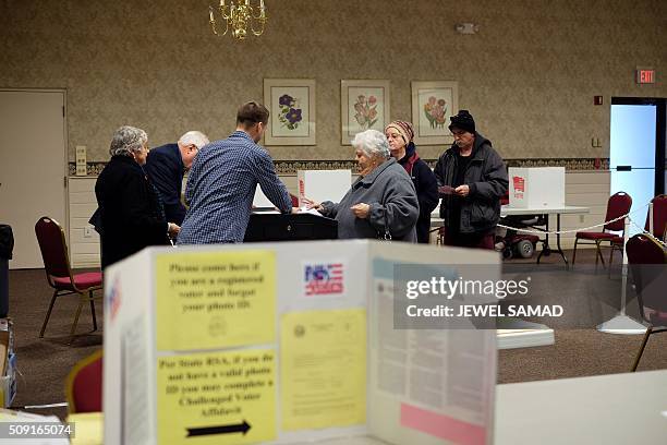 Woman casts her ballot for the first US presidential primary at a shrine in Concord, New Hampshire, on February 9, 2016. New Hampshire voters headed...