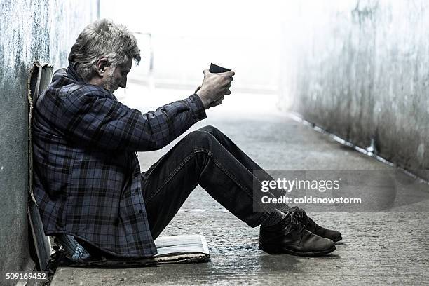 obdachlos senior erwachsener mann sitzt und betteln im u-bahn tunnel - beggar stock-fotos und bilder