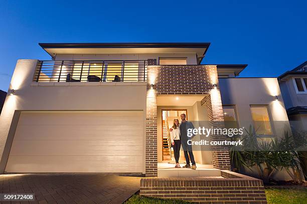 couple standing in front of their new home - front door open stock pictures, royalty-free photos & images