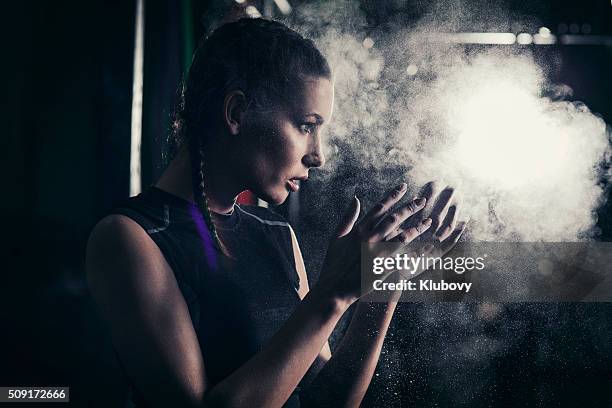 young woman applying sports chalk on her hands - female bodybuilder stock pictures, royalty-free photos & images