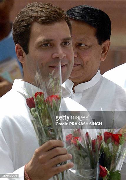Son of India's Congress Party President Sonia Gandhi, and newly elected Member of Parliament Rahul Gandhi clutches a bouquet of flowers as he arrives...