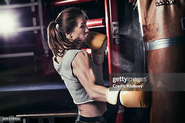 female boxer training with a punching bag - slaan met vuist stockfoto's en -beelden