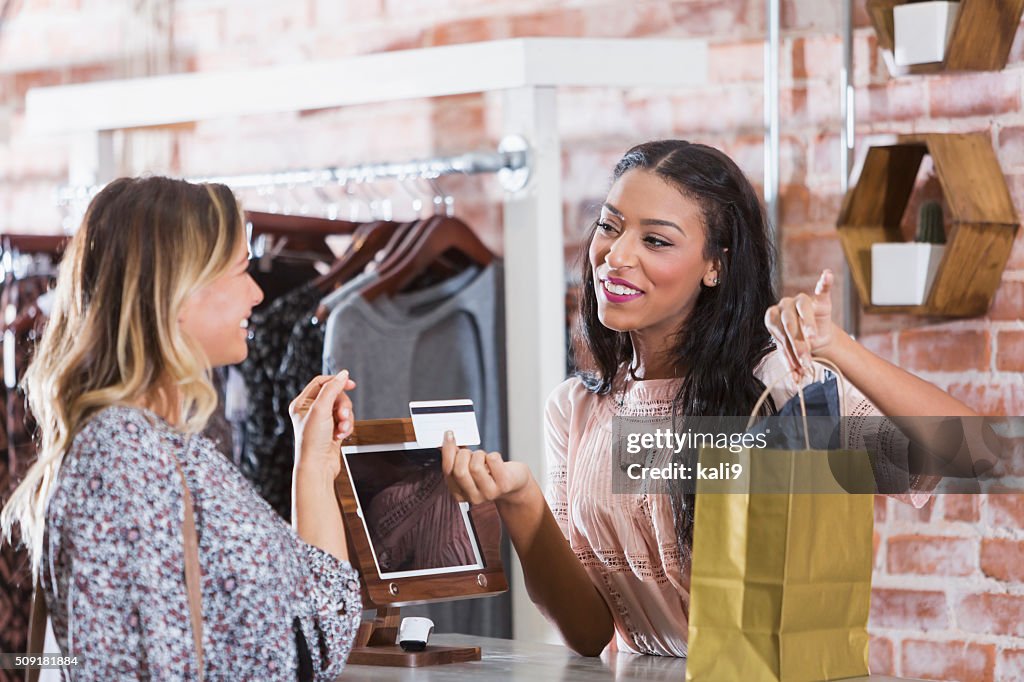 Cashier helping customer at checkout counter of store