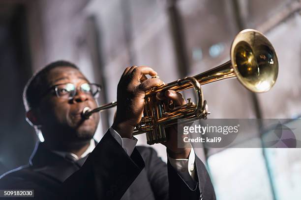 schwarzer mann spielt trompete - trompete stock-fotos und bilder