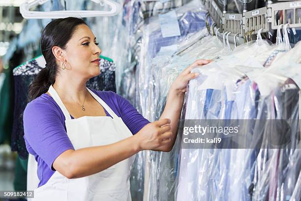 hispanic frau arbeitet in chemische reinigung - dry cleaner stock-fotos und bilder