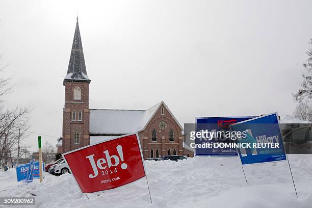 Campaign signs are seen in the snow outside a polling location, February 9 in Concord, New Hampshire. Voters head to the polls for the hundredth year...