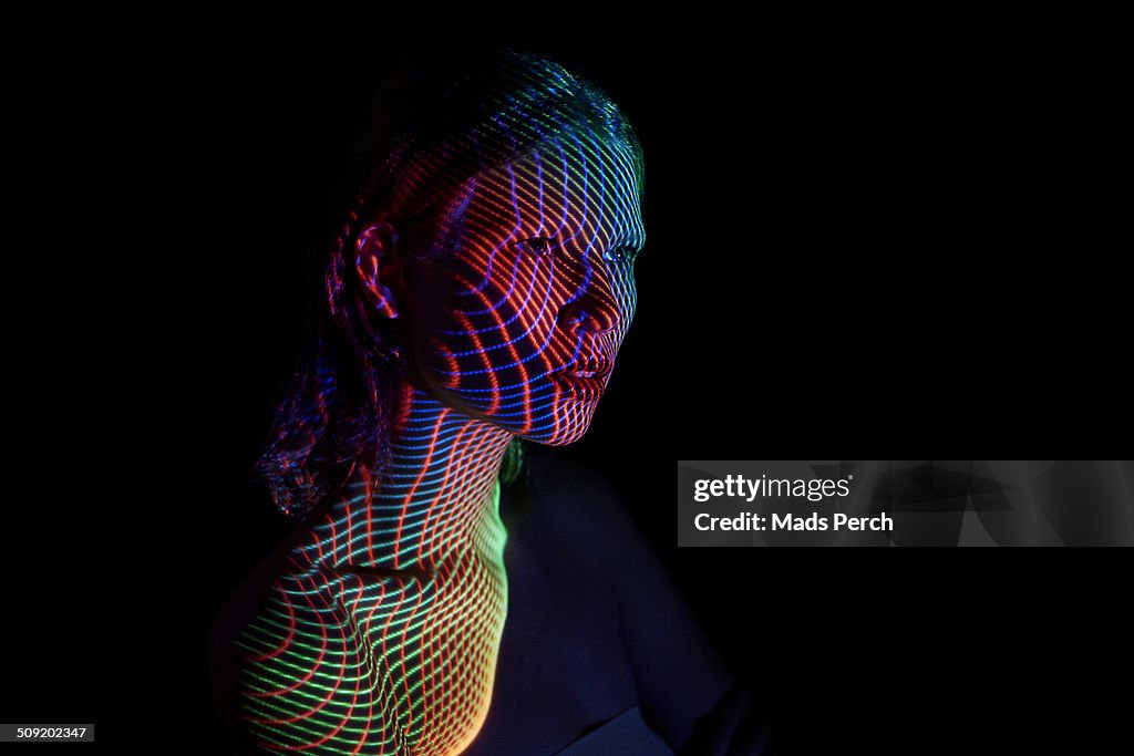 Young Woman Covered by futuristic Lines of Lights