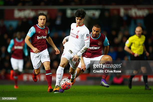 Joao Carlos Teixeira of Liverpool evades Mark Noble and Winston Reid of West Ham United during the Emirates FA Cup Fourth Round Replay match between...