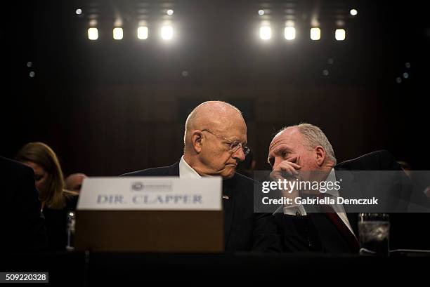 Director of National Intelligence James Clapper speaks to CIA Director John Brennan before the start of the Senate Intelligence Committee hearing at...