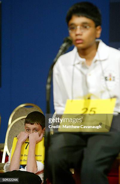 David Tidmarsh of South Bend, Indiana, peers over his placard as his final opponent Akshay Buddiga, of Colorado Springs, Colorado, spells a word...