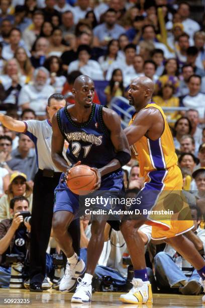 Kevin Garnett of the Minnesota Timberwolves handles the ball while defended by Karl Malone of the Los Angeles Lakers in Game Six of the Western...