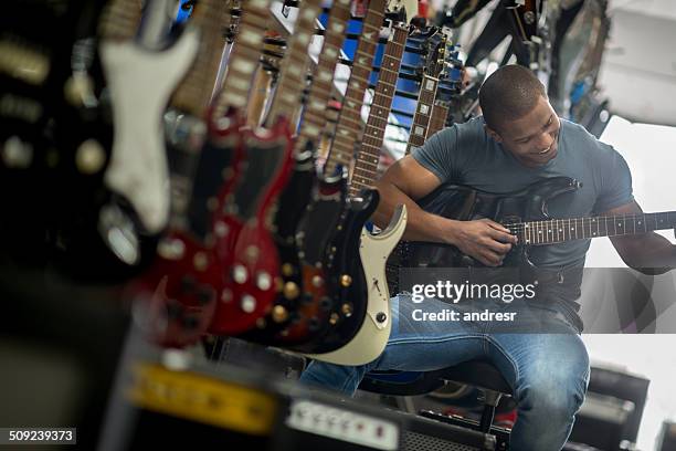 man playing the guitar - guitar shop stock pictures, royalty-free photos & images