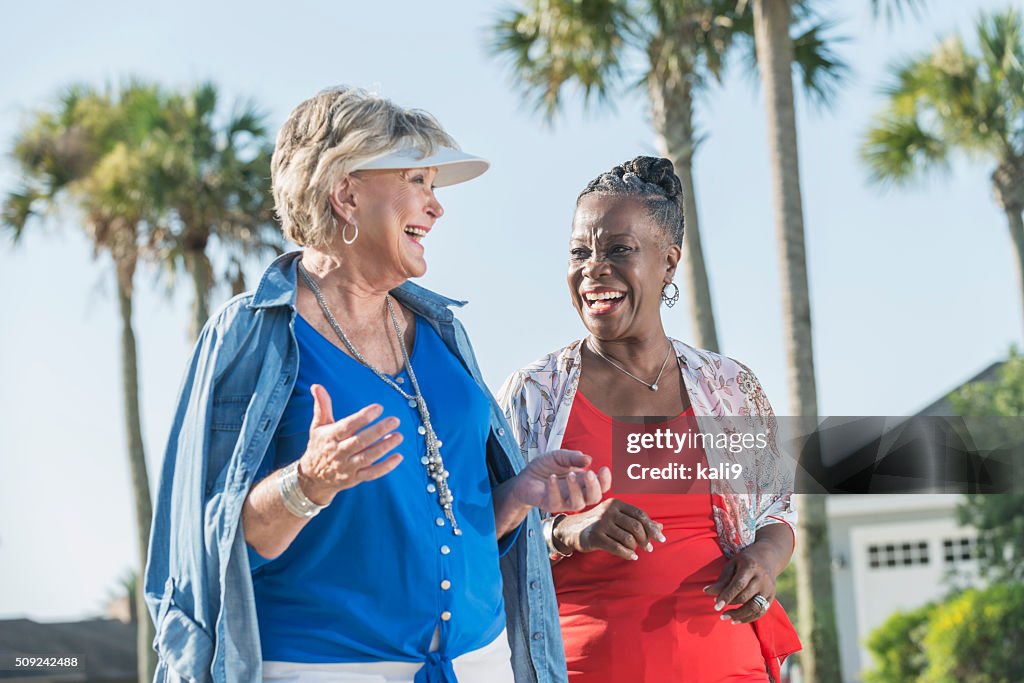 Two senior women walking and talking outdoors