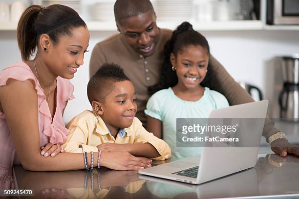 familie gerade eine video auf dem laptop - schwarz ethnischer begriff stock-fotos und bilder