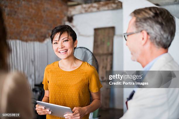 happy businesswoman discussing in creative office - mature business woman digital tablet corporate professional stockfoto's en -beelden