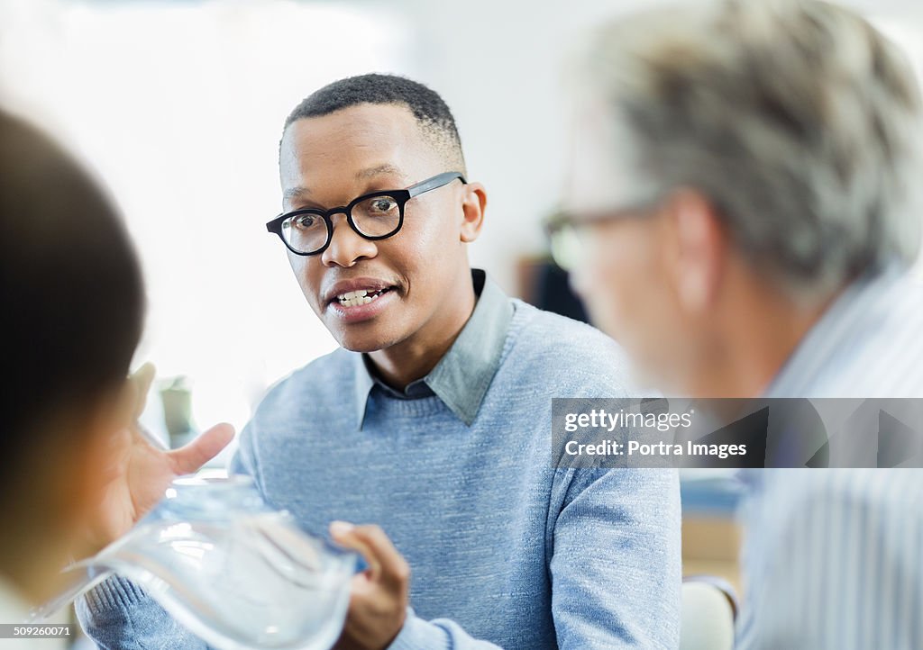 Businessman explaining glass model to colleagues