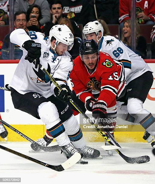 Artem Anisimov of the Chicago Blackhawks knocks the puck away from Chris Tierney of the San Jose Sharks at the United Center on February 9, 2016 in...